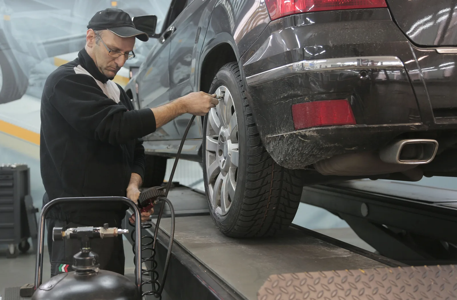 Person prüft ein Autorad in einer Werkstatt, Stockmotiv